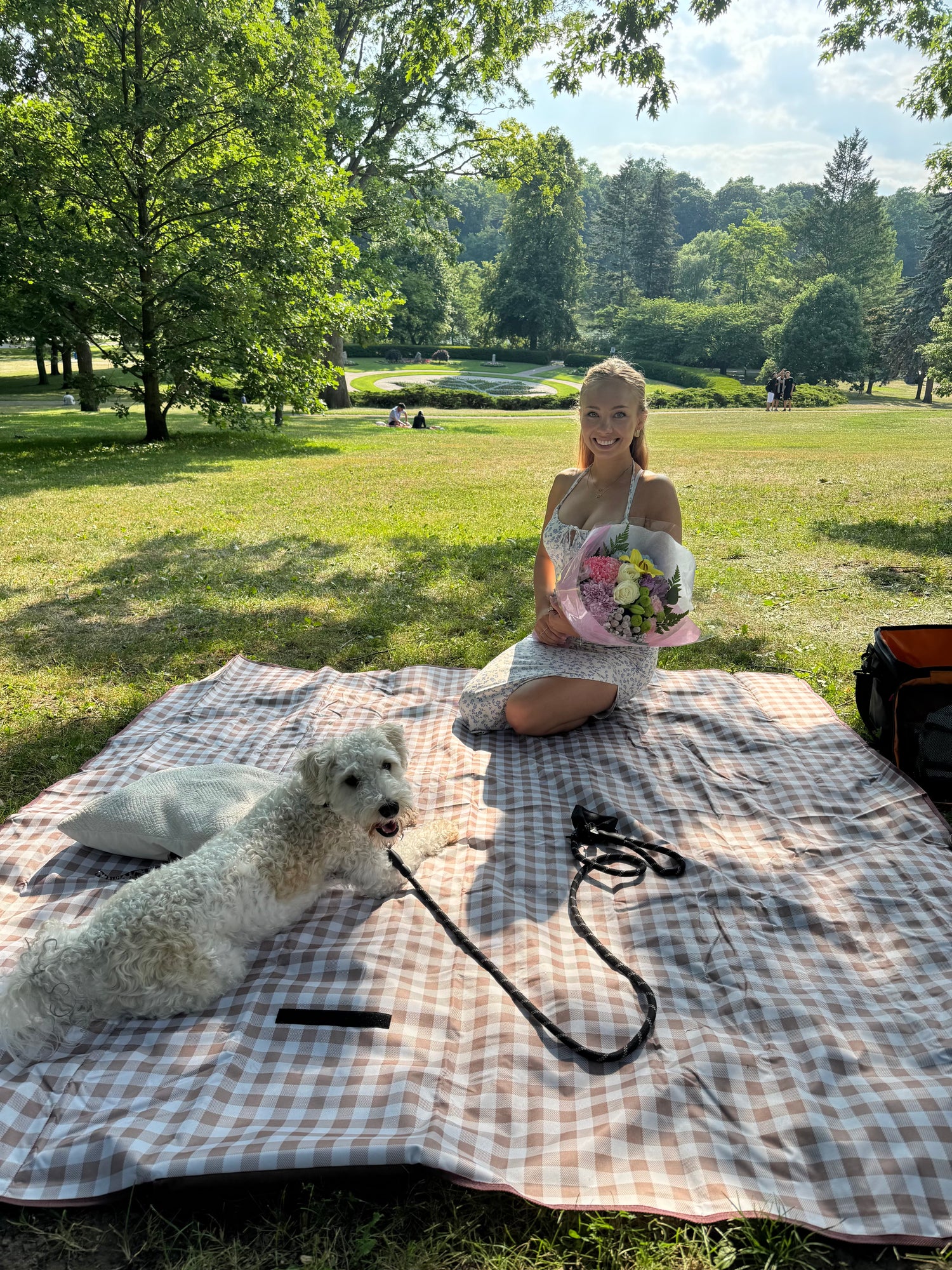 Leo Daughter small business owner with her dog on a checkered blanket in a park