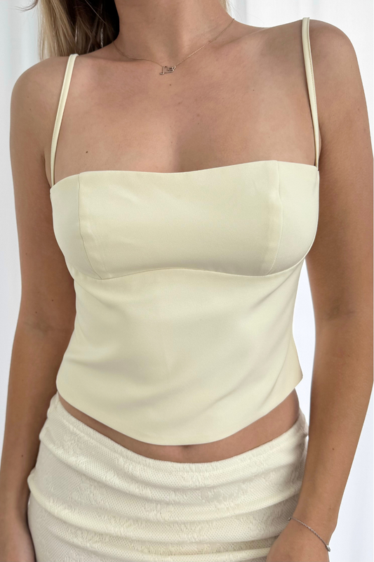 Light cream tank top worn by a person on a white background