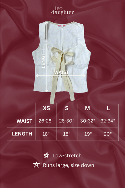 White sleeveless top with a bow on a red fabric background, featuring a size chart.